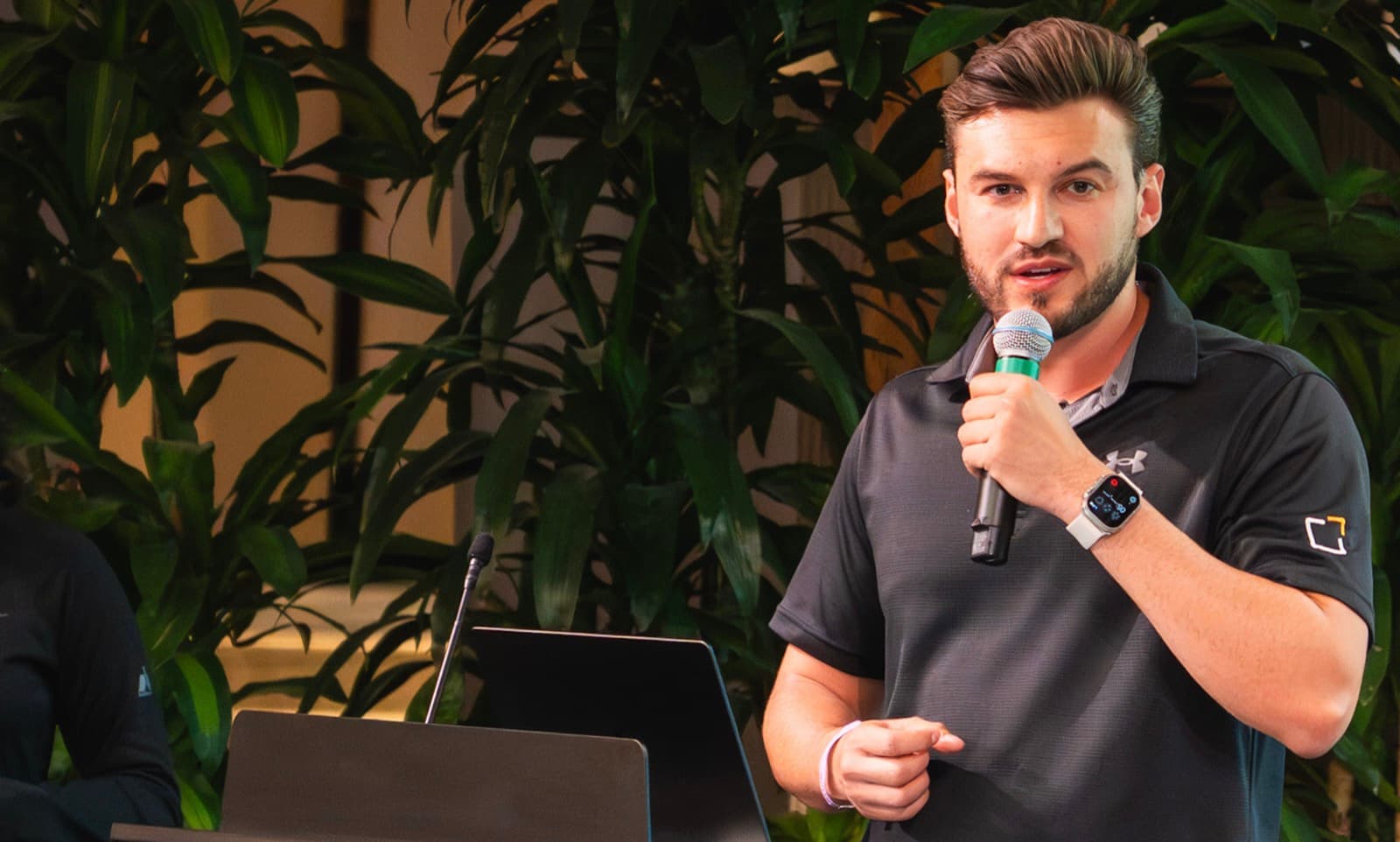 Roan Weigert holding a microphone and speaking to a room